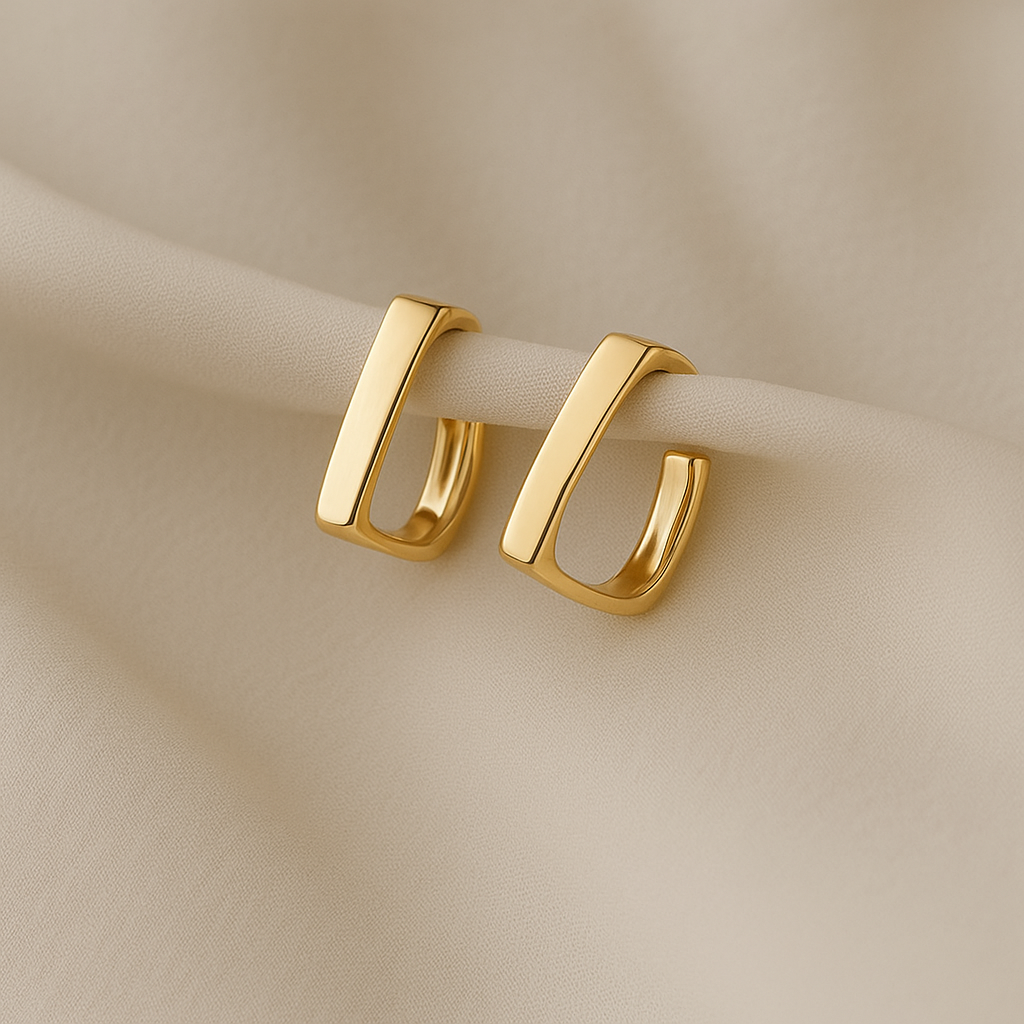 Bold Edge Gold Hoop Earrings on a beige fabric background