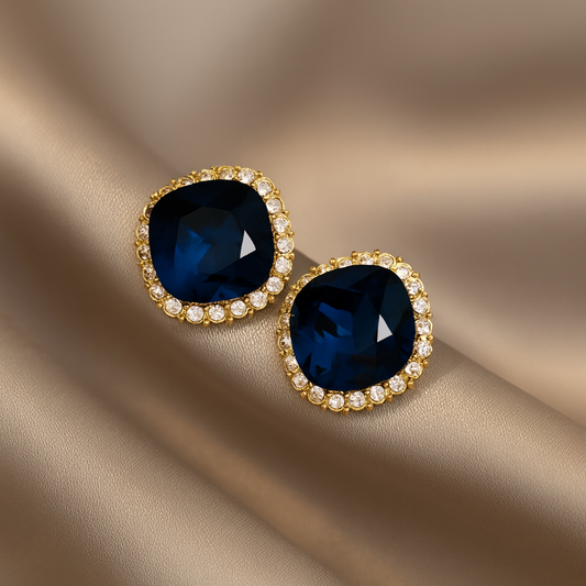 Midnight Aura Blue Stone Stud Earrings on a beige fabric background